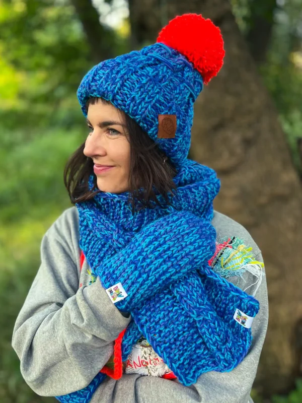 Czapka z wielkim pomponem MERINO 66% ,,Niebieskości" EUFORIA 7 Stylowa niebieska czapka z pomarańczowym pomponem, ręcznie tworzona przez seniorki z Poznania.